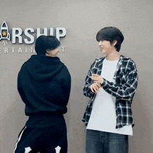 two men standing in front of a sign that says arship