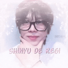 a close up of a person wearing glasses with the words shinyu de regi on the bottom .