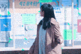 a woman is standing in front of a bulletin board with a sign that says 4580 on it