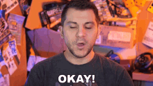 a man with his eyes closed and the word okay on his shirt
