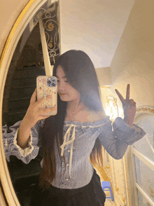 a woman taking a picture of herself in the mirror with her phone