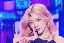 a girl with pink hair is making a peace sign