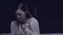 a woman is crying while holding a piece of paper .
