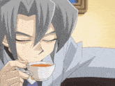 a man with gray hair drinking a cup of tea