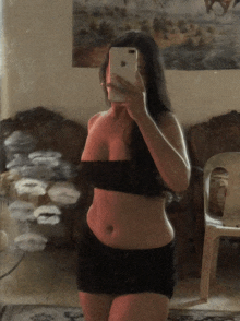 a woman is taking a selfie in front of a mirror