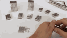 a person is holding a piece of metal that looks like a cube
