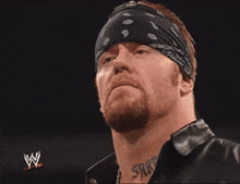 a man with a bandana on his head is holding a microphone