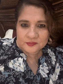 a woman wearing a blue and white floral shirt