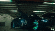 a man is sitting in a black sports car with the doors open