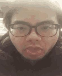 a man wearing glasses is making a funny face with his mouth open