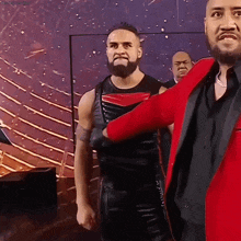 a man in a red jacket is standing next to another man