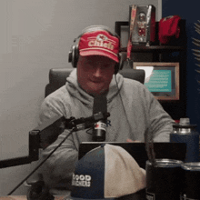 a man wearing a chiefs hat and headphones