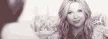 a woman is smiling in a black and white photo while looking at a man .