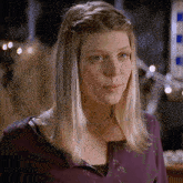 a woman with blonde hair wearing a purple sweater