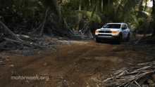 a white suv is driving down a dirt road with motorweek.org written on the bottom right
