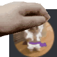 a close up of a person 's hand holding a cookie with a cat behind it .