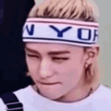 a close up of a person wearing a headband with the word ny on it .