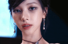 a close up of a woman wearing earrings and a choker necklace