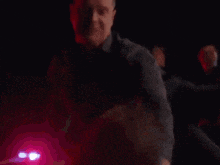 a man is being arrested by police officers in a dark room .