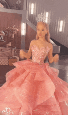 a woman in a pink gown with a crown on her head