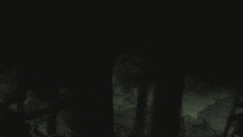a dark room with a shadow of a person standing in the corner
