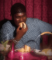 a man sitting at a table eating a sandwich