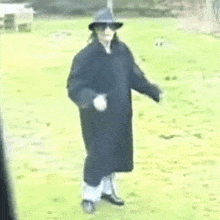 a man in a hat and sunglasses is standing in a field .