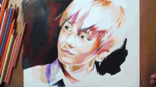 a drawing of a young boy with colored pencils on the table