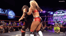 two women wrestling in a ring with a crowd watching and a sign that says wwe now
