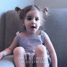 a little girl is sitting on a couch with the words i had a long day i 'm so stressed