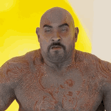 a bald man with a beard has a tattoo on his chest