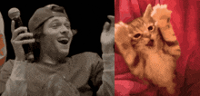 a man holding a microphone next to a cat peeking out from behind a red curtain