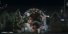 a man in a black shirt is dancing in front of a christmas tree and gifts with the name pranay on the bottom