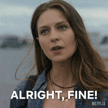 a woman with a necklace and a denim shirt says alright fine