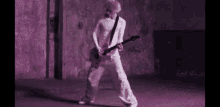 a man is playing a guitar in a purple room .
