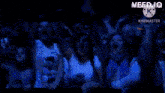 a crowd of people with their arms in the air and the word kinemaster on the bottom right