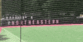 the word northeastern is written on a black fence