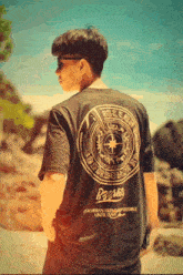 a man wearing a black t-shirt that says always seems impossible