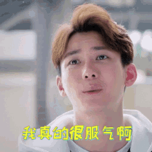 a close up of a young man 's face with chinese writing behind him