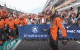 a man stands in front of a sign that says crypto.com on it