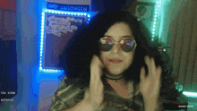 a girl wearing sunglasses is standing in front of a sign that says happy halloween