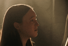 a close up of a woman 's face with the sun shining on it