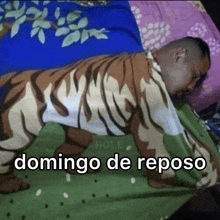a man is laying on a bed with a blanket that looks like a tiger
