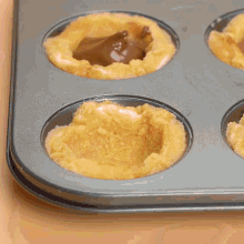 a person is pouring chocolate into a muffin pan
