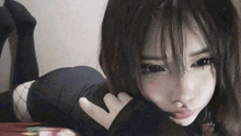 a young girl is laying on her stomach on a bed making a funny face .