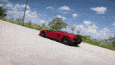 a red sports car is driving down the road