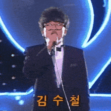 a man in a tuxedo singing into a microphone with chinese writing on the bottom