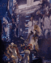 a group of people are dancing on a stage and one of them is wearing a plaid shirt