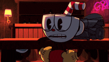 a cartoon character with a red and white cane is sitting at a table