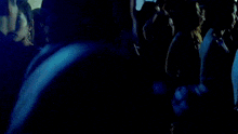 a group of people are hugging each other in a dark room